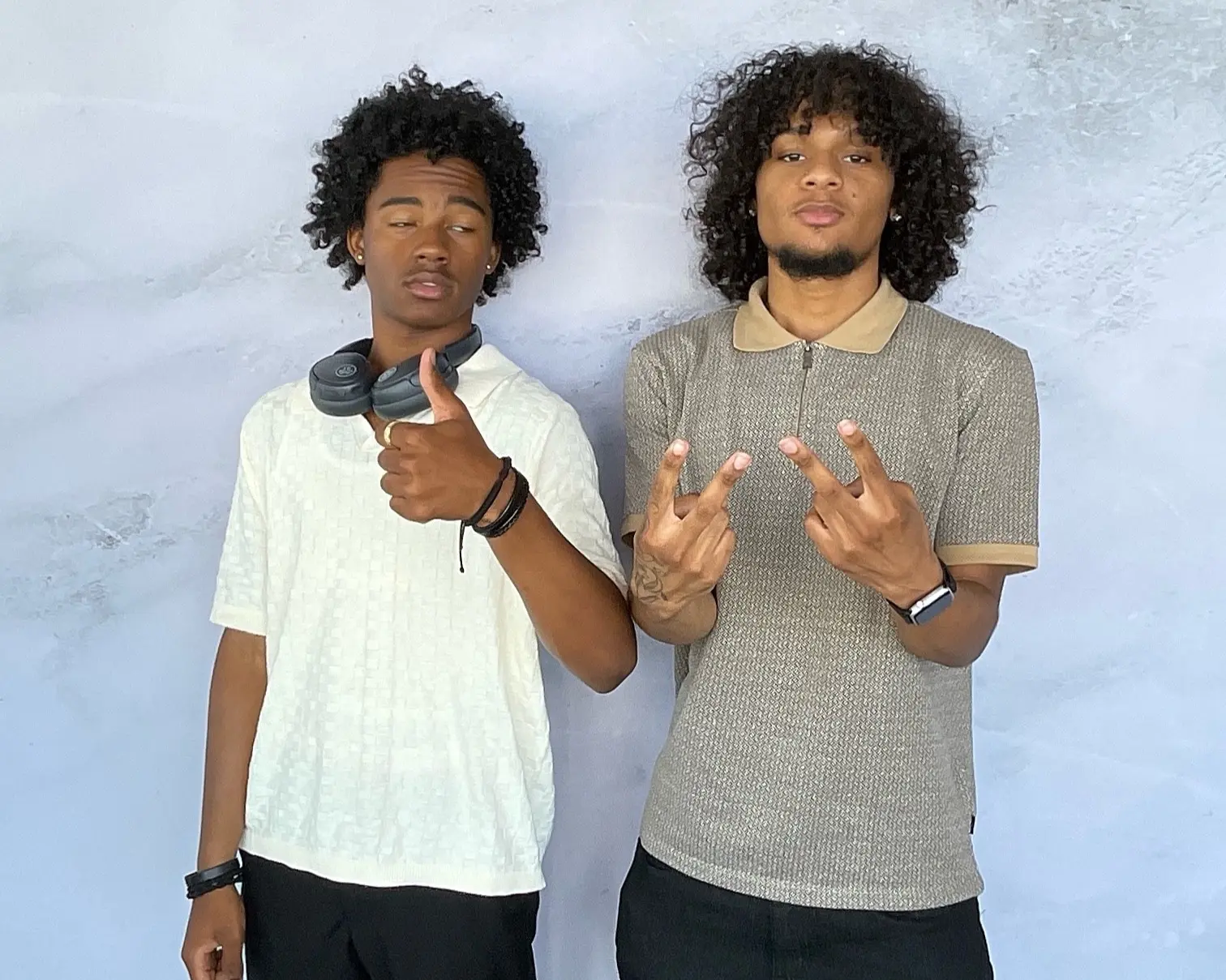 Two young men sharing a playful photo booth pose