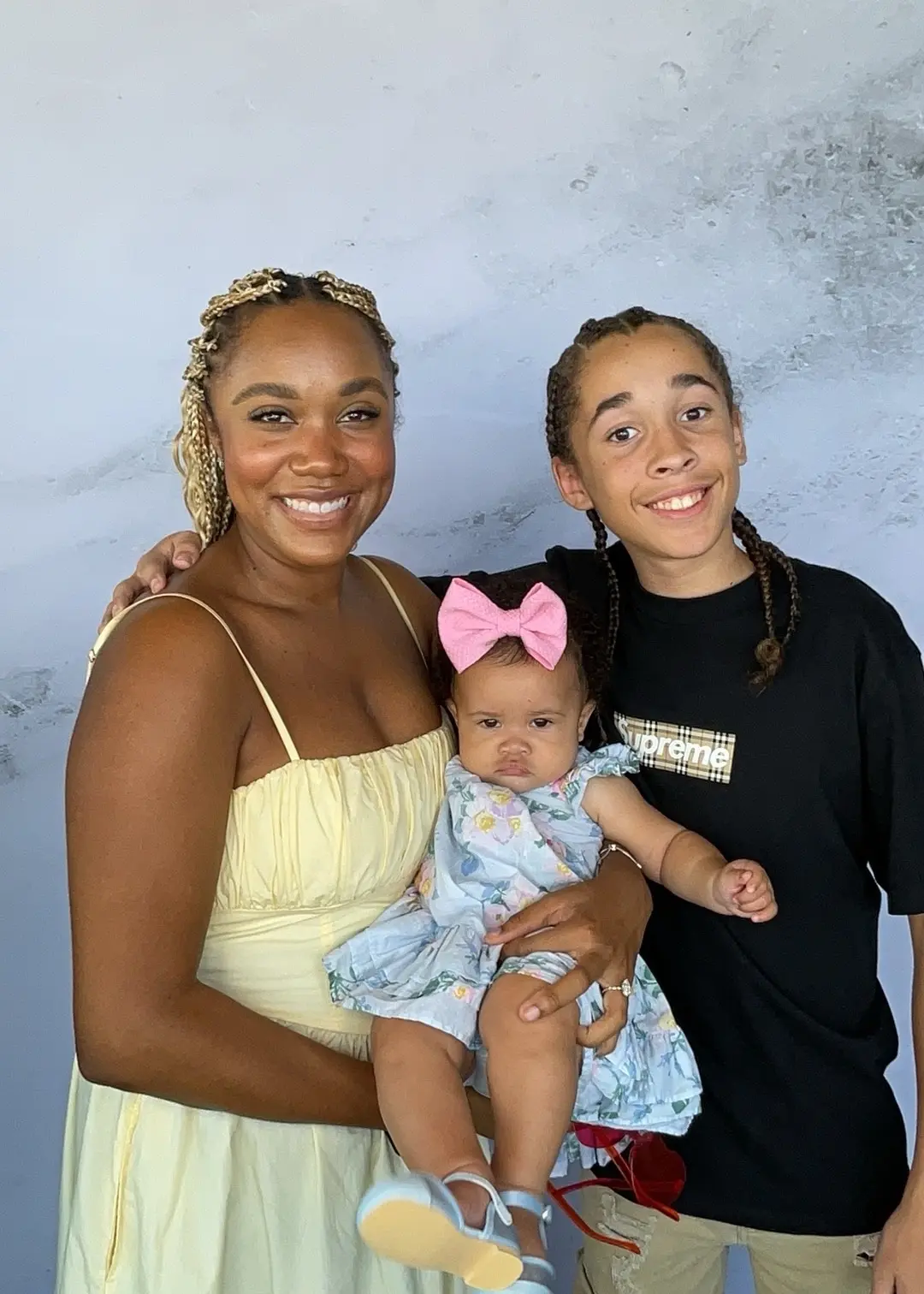 Woman holding a baby beside a smiling young family member