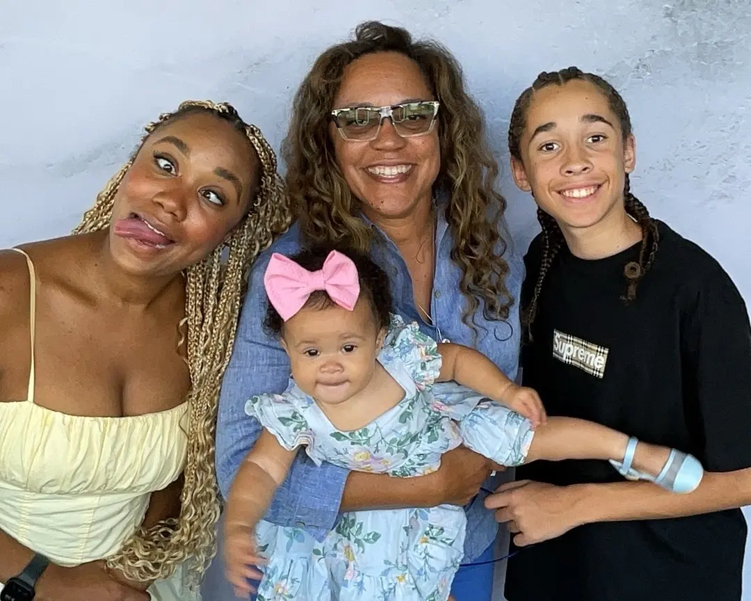 Four family members gathering around a baby for a playful portrait