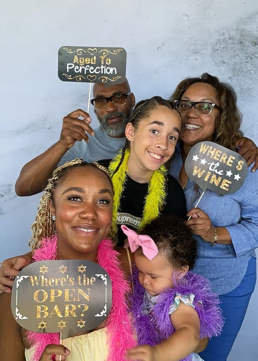 Multigenerational family posing with milestone birthday props