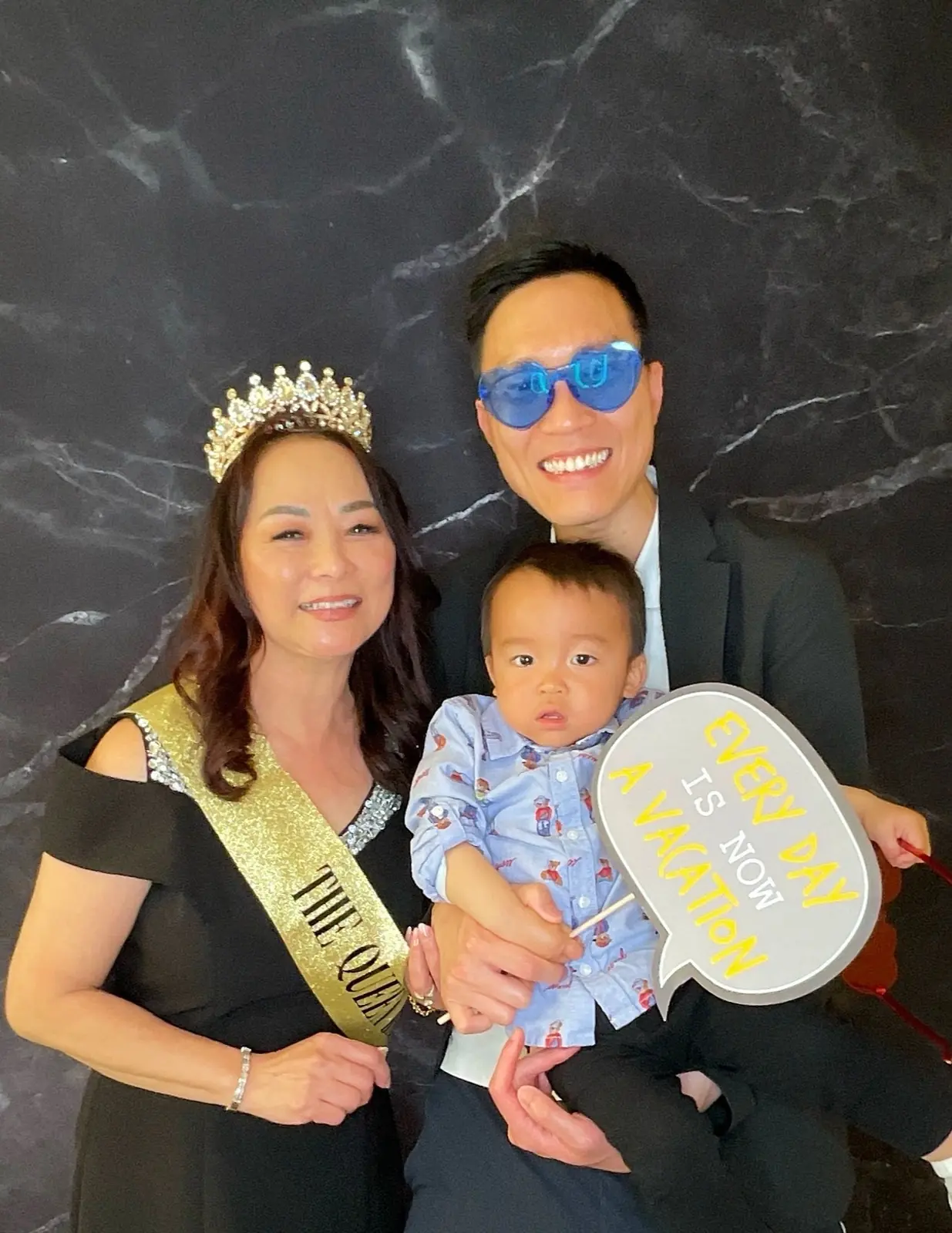 Family posing with the retirement guest of honor and a vacation-themed prop
