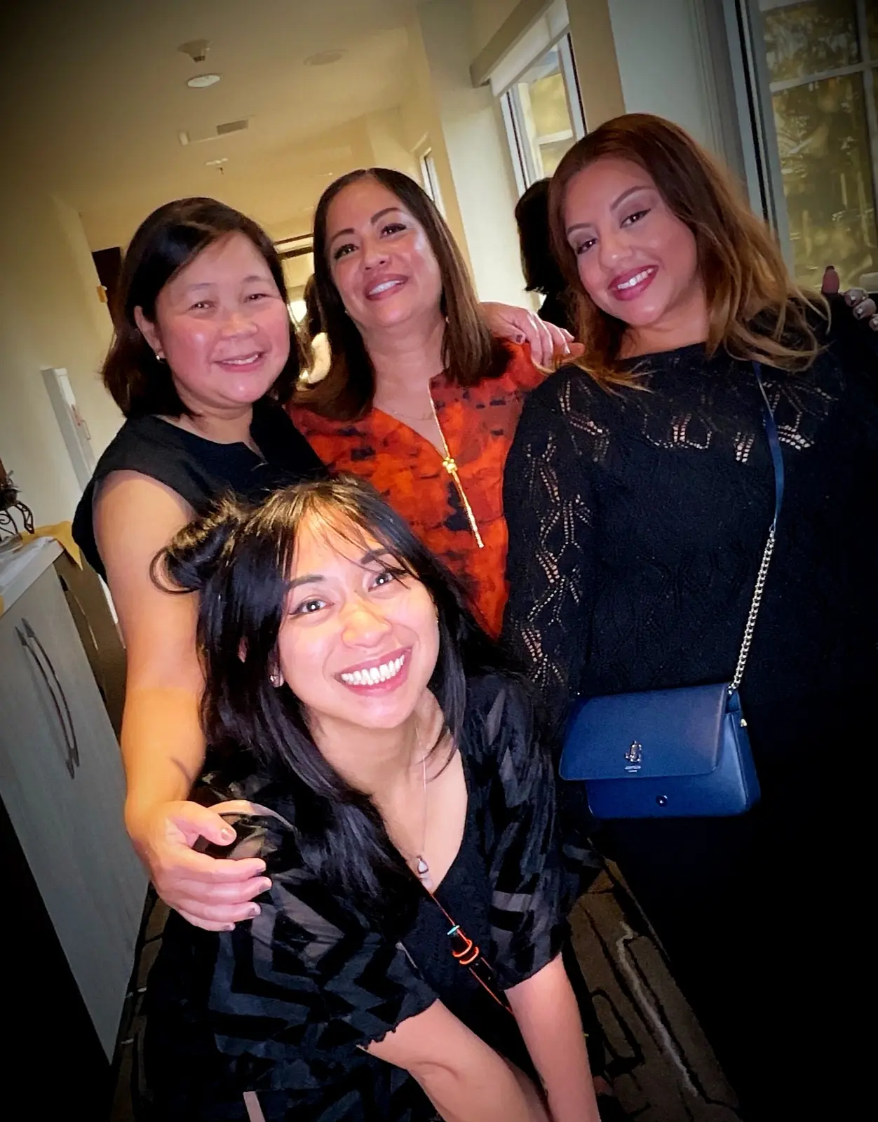 Four friends smiling together during a retirement celebration in San Mateo
