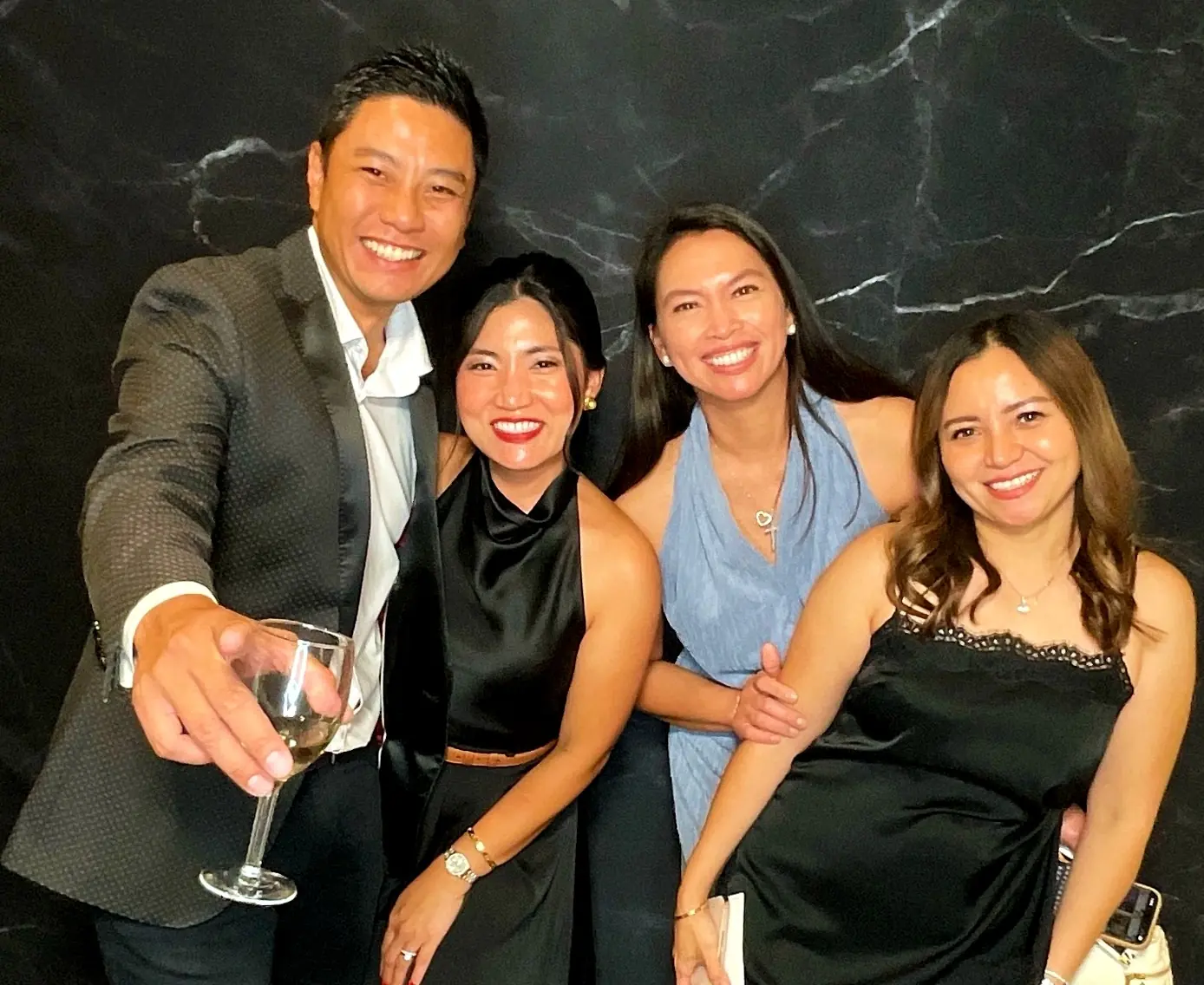 Four guests raising a glass and smiling at the retirement party