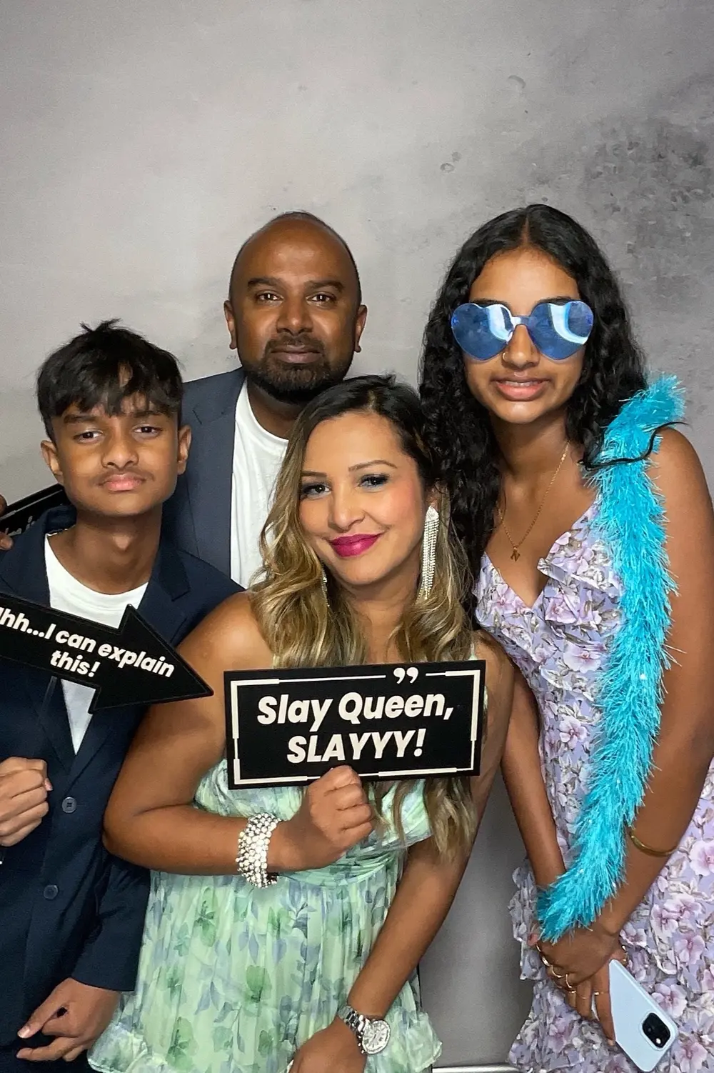 Four family members smiling together at the wedding photo booth