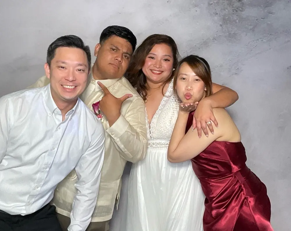 Bride and two guests sharing a playful reception photo booth pose