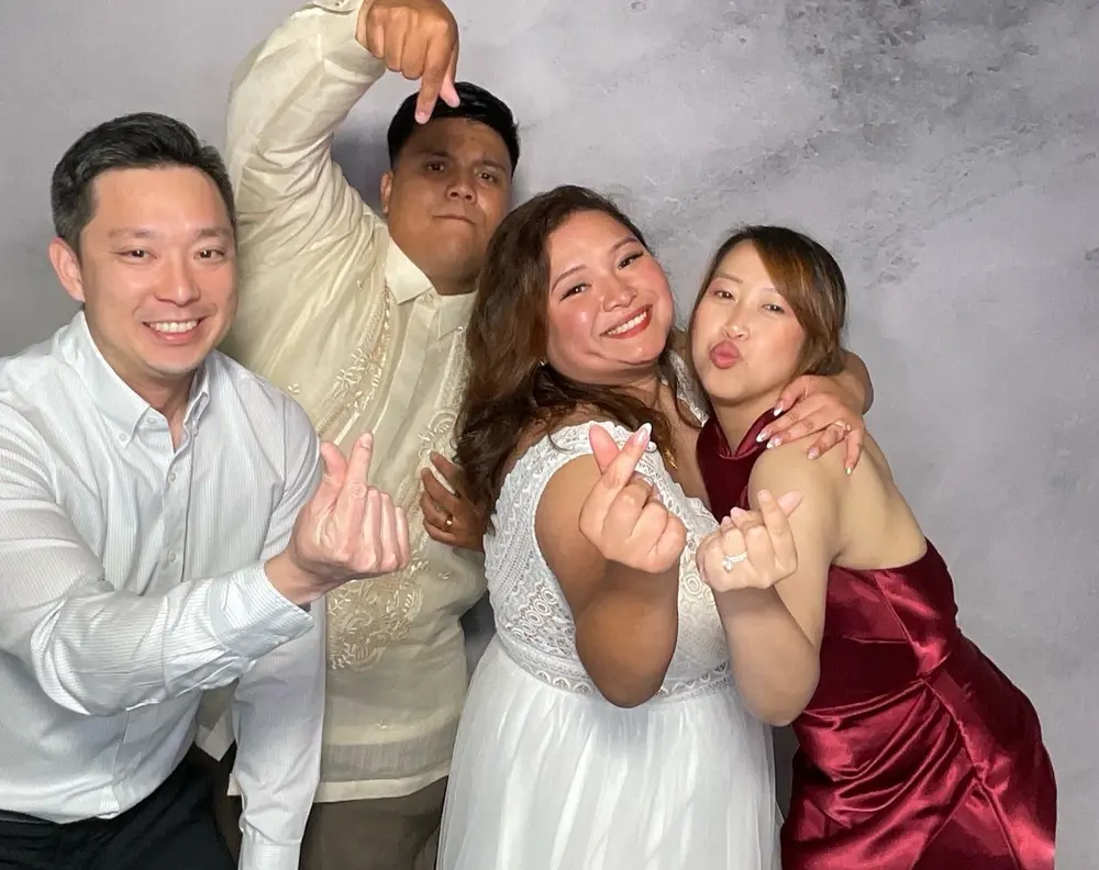 Bride and two guests pointing toward the camera during the reception