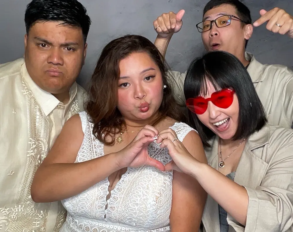Bride and friends making heart hands together in the photo booth