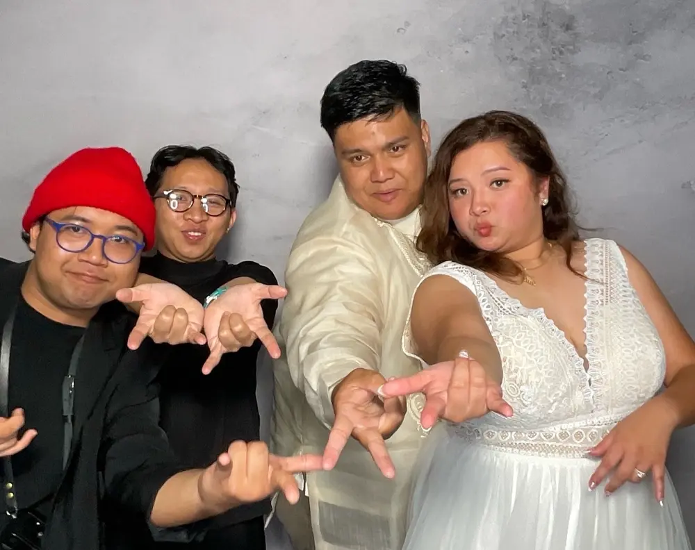 Bride and four guests reaching toward the camera in a fun group pose