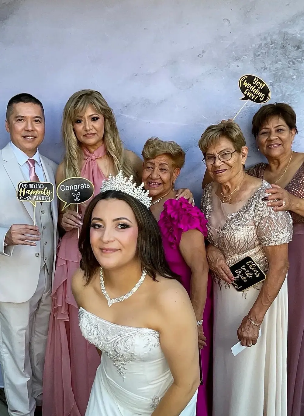 A bride celebrating with family members in a photo booth