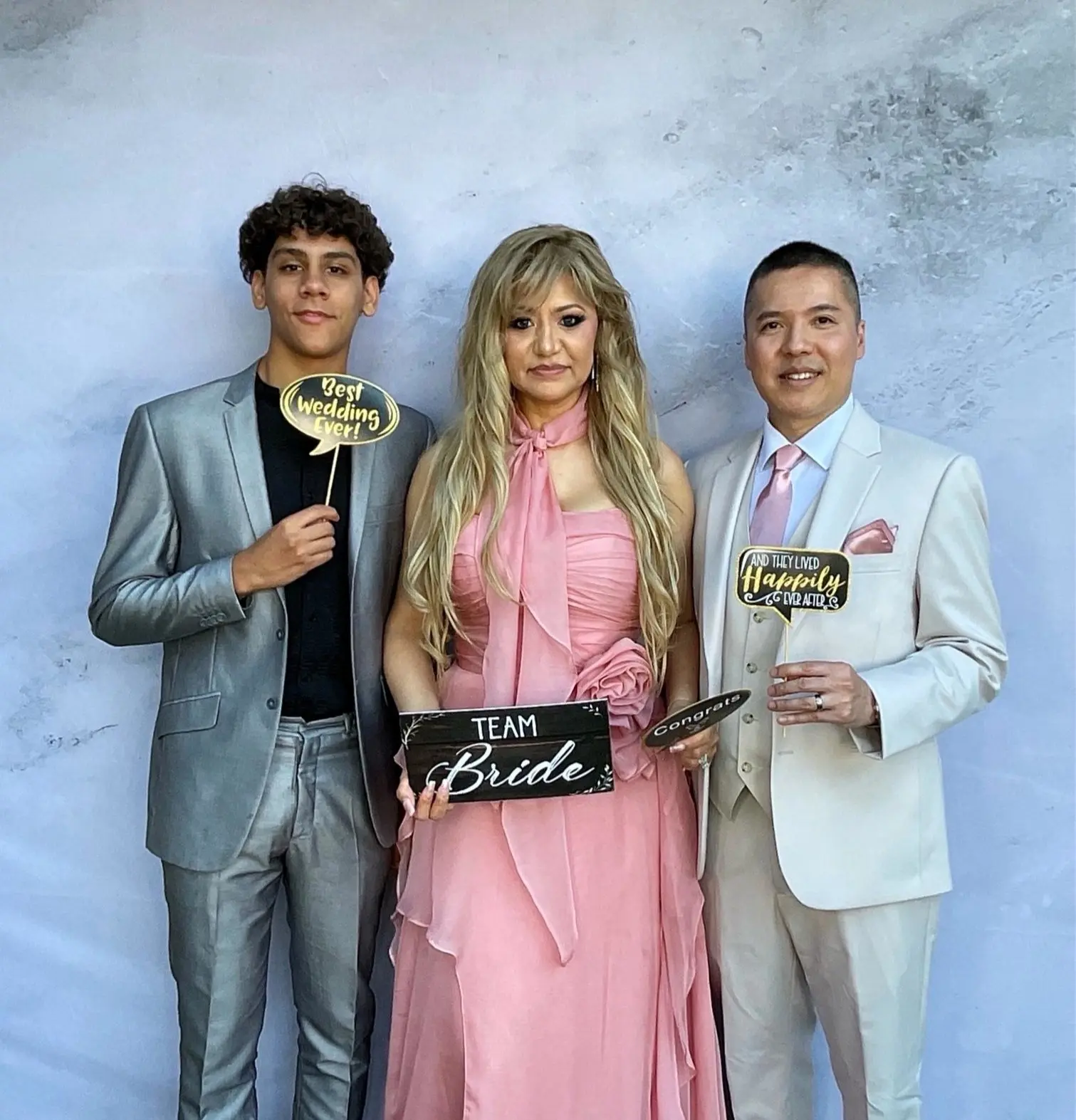 Family members posing with wedding signs