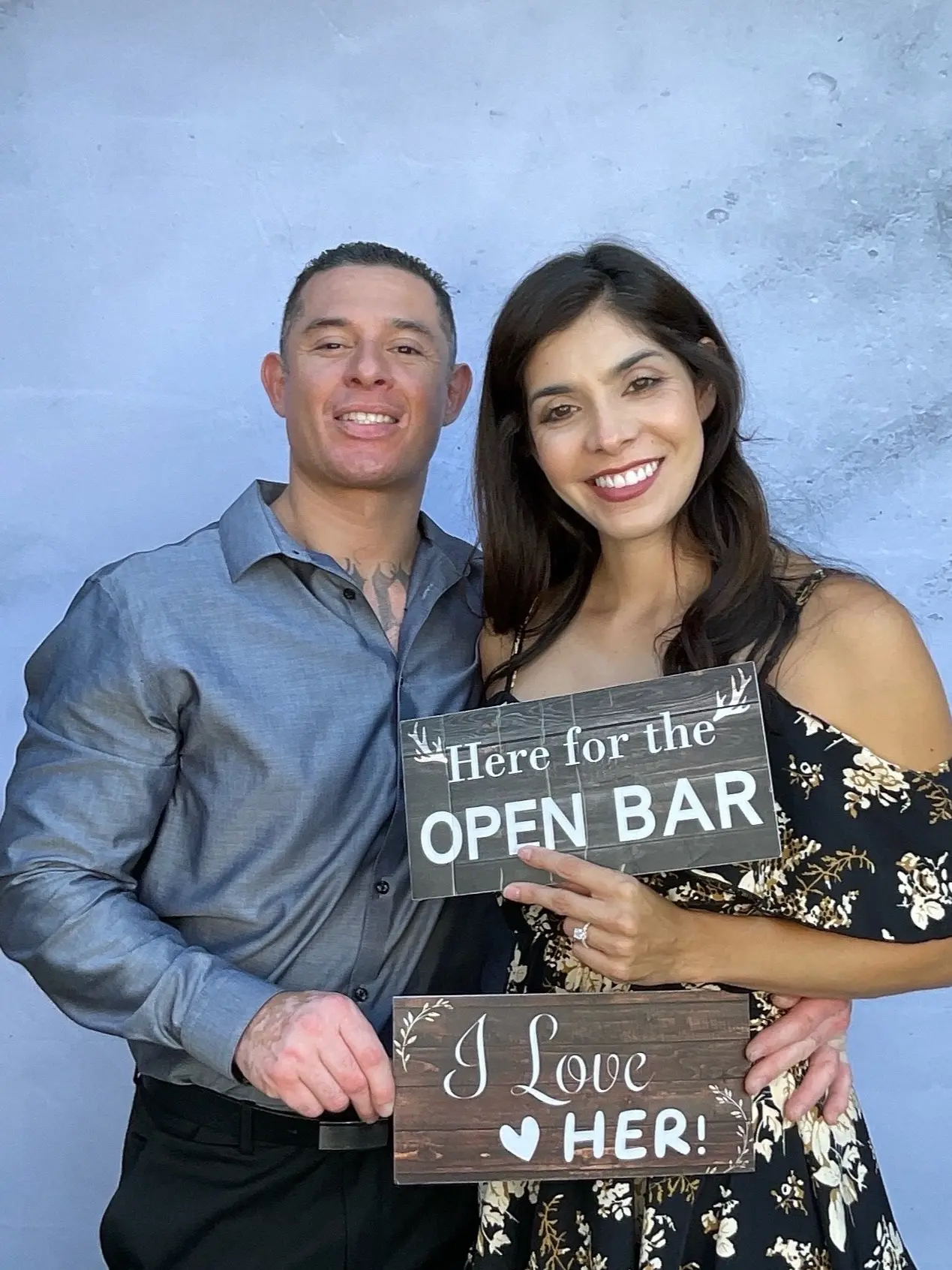 A wedding couple smiling with playful reception signs