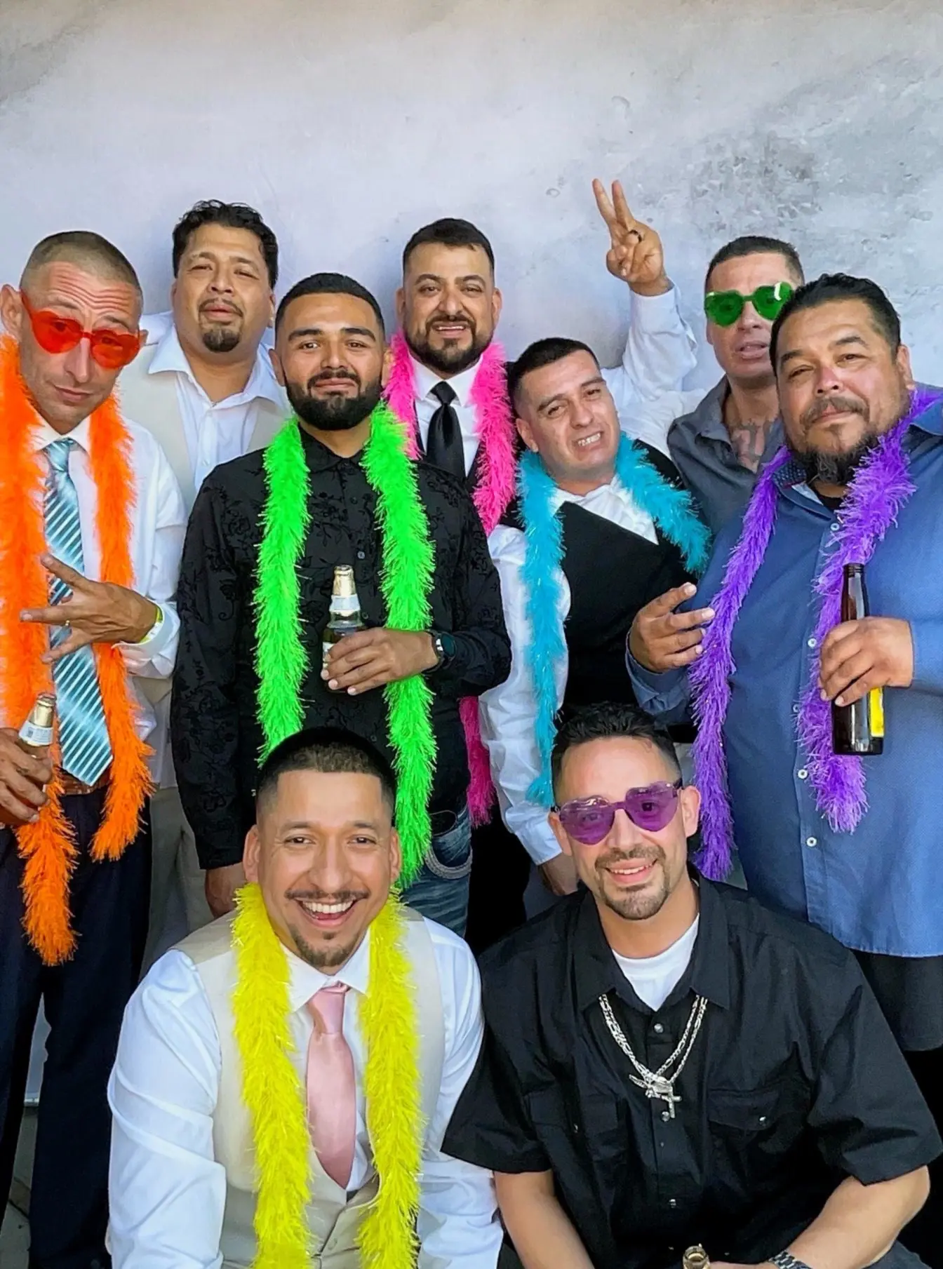 A large group of wedding guests wearing colorful boas